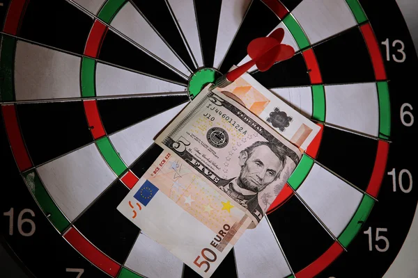 Money pierced by arrow on dartboard close up — Stock Photo, Image