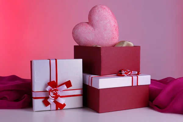 堆礼品盒和装饰的心脏，在彩色背景 — 图库照片