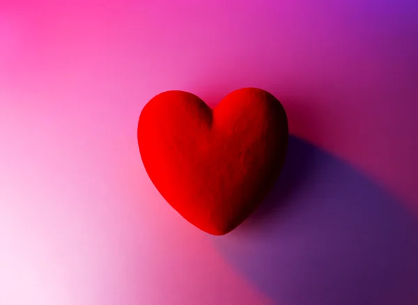 Декоративно-красное сердце, на цветном фоне — стоковое фото