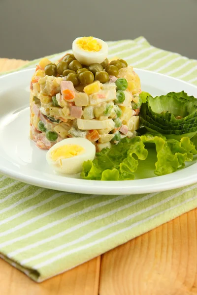 Salada tradicional russa Olivier, em guardanapo de cor, em fundo de madeira — Fotografia de Stock