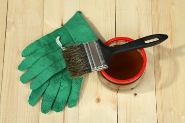 Parlak arkaplanda, ahşap çitlere koruyucu cila uygulanıyor