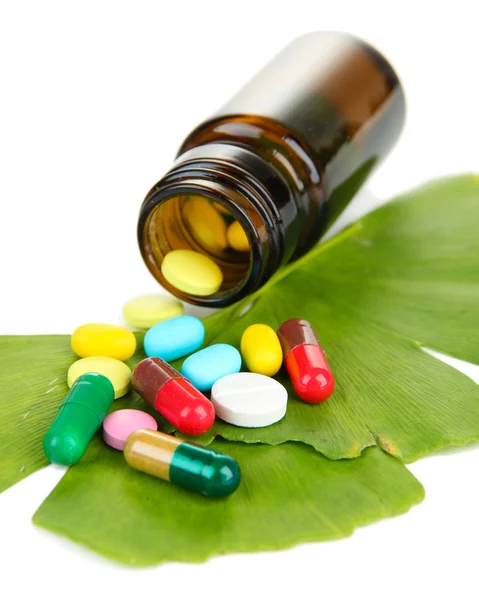 Ginkgo biloba leaves and medicine bottle with pills isolated on white — Stock Photo, Image