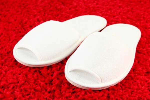 Pantofole bianche su sfondo tappeto — Foto Stock