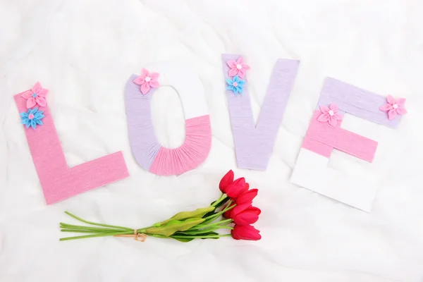Palavra Amor criado com quintal de tricô brilhantemente colorido no fundo do tecido — Fotografia de Stock