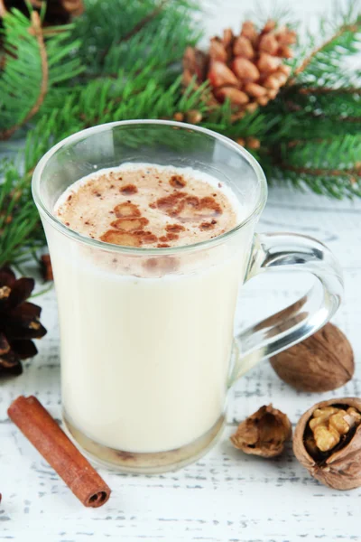 Cup of eggnog with fir branches on wooden background — Stock Photo, Image