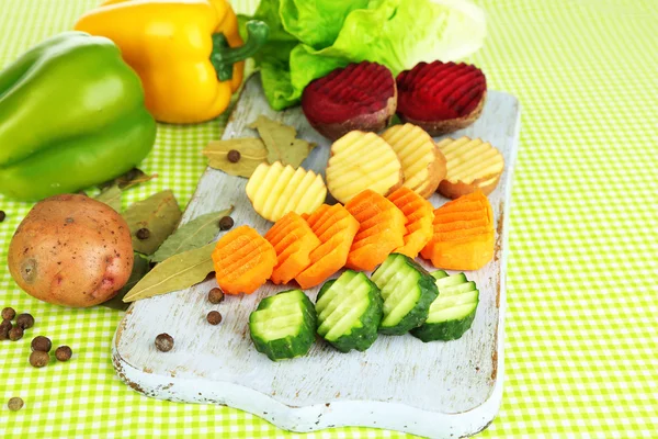 Belle verdure a fette, sul tagliere, sullo sfondo di colore — Foto Stock