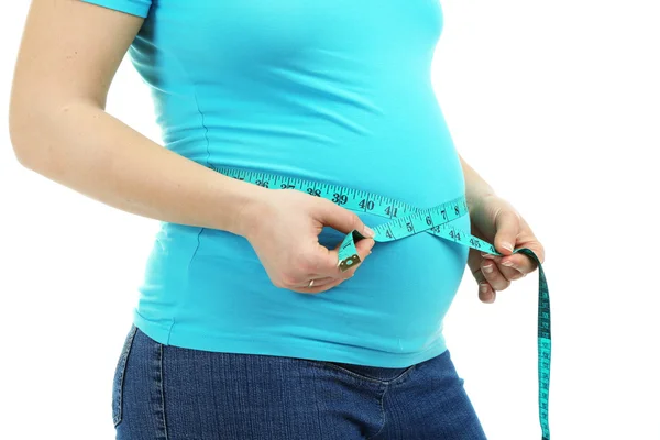 Pregnant woman measuring her belly isolated on white — Stock Photo, Image