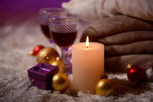 Composition avec plaids, bougies et décorations de Noël, sur tapis blanc sur fond lumineux — Photo