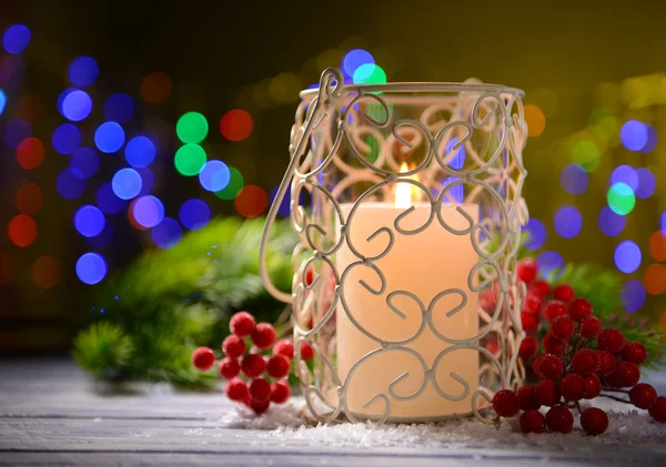 Vela e broto de árvore de Natal na mesa de madeira no fundo brilhante — Fotografia de Stock