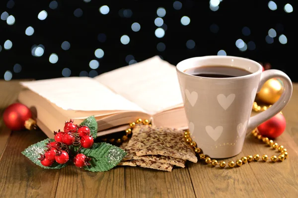 Samenstelling van boek met kop van koffie en Kerst decoraties op tafel op donkere achtergrond — Stockfoto