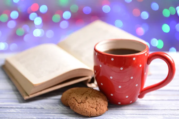 Composition of book with cup of coffee on table on bright background — Stock Photo, Image