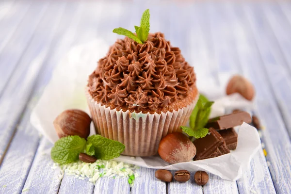 Välsmakande cupcake med smörkräm, på trä färgtabell på ljus bakgrund — Stockfoto