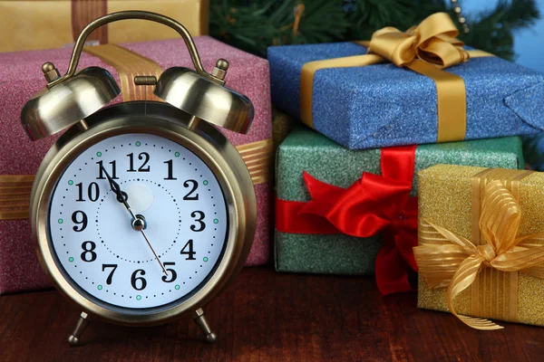 Reloj despertador con regalos en mesa de madera de cerca — Foto de Stock