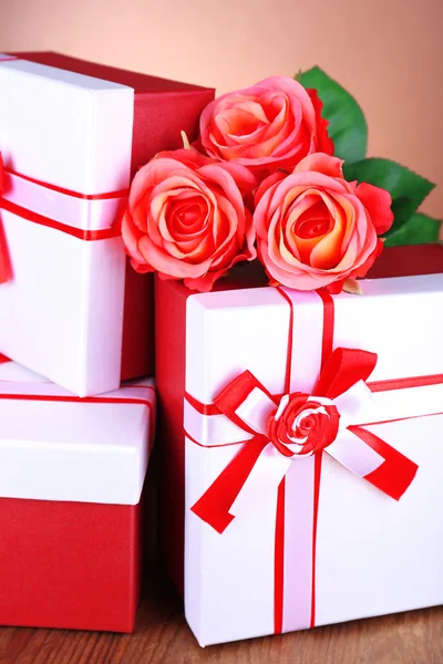 Caixas de presente bonitas com flores na mesa sobre fundo marrom — Fotografia de Stock