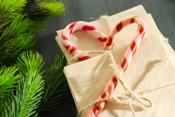 Christmas candy canes and letters for Santa, on color wooden background — Stock Photo, Image