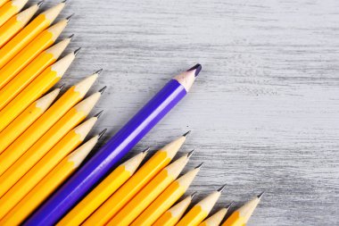 Celebratory pencil among usual pencils, on color background clipart