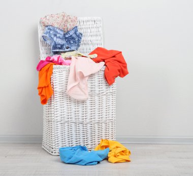 gri zemin üzerine ahşap zemin üzerinde tam çamaşır sepeti