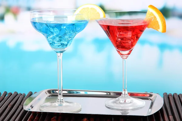 Bicchieri di cocktail sul tavolo vicino alla piscina — Foto Stock