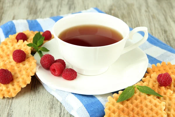 Taza de té con galletas y frambuesas en primer plano de la mesa —  Fotos de Stock