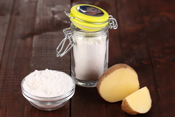 Starch in bowl and bank on wooden table close-up — Stock Photo, Image