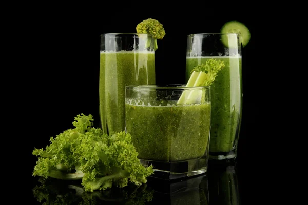 Gläser mit grünem Gemüsesaft und Salat isoliert auf schwarz — Stockfoto