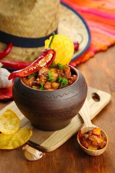 Chili Mais Carne - traditionelles mexikanisches Essen, im Topf, auf Serviette, auf Holzgrund — Stockfoto