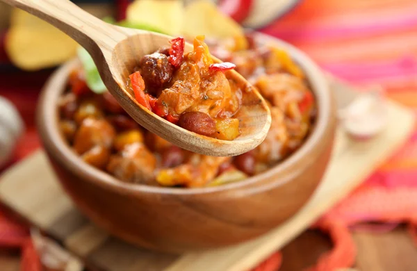 Carne de maíz con chile - comida tradicional mexicana, en tazón de madera, en servilleta, sobre fondo de madera —  Fotos de Stock