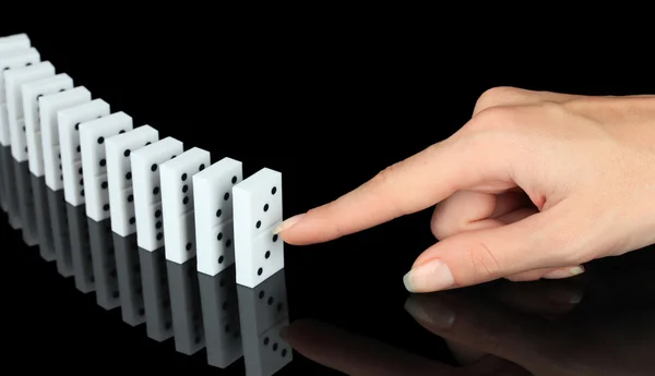 Hand pushing dominoes isolated on black — Stock Photo, Image