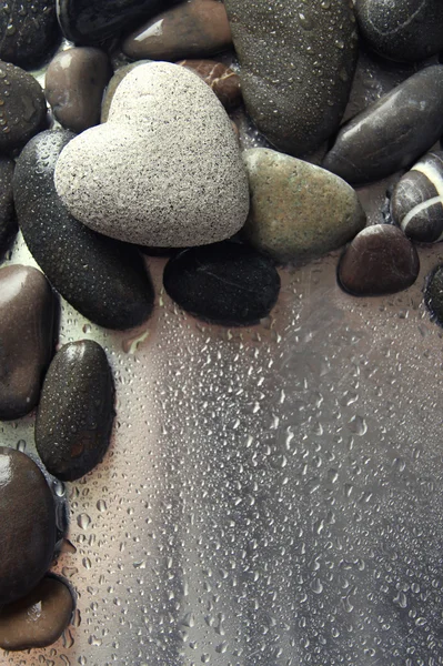 Grey stone in shape of heart, on light background — Stock Photo, Image