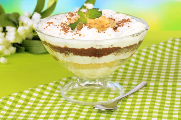 Leckeres Dessert mit Banane und Karamell auf Tisch auf hellem Hintergrund — Stockfoto