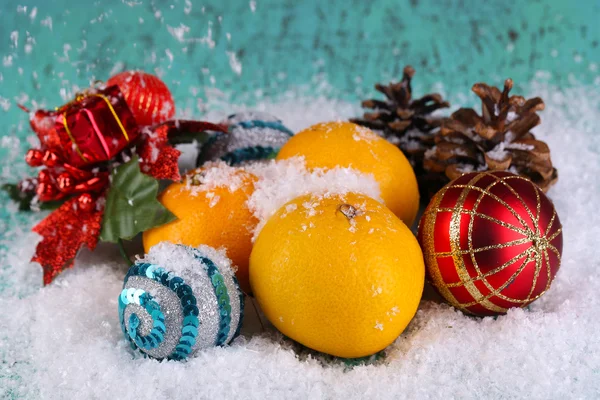 Mandarinen und Weihnachtsspielzeug auf Holztisch im Schnee — Stockfoto