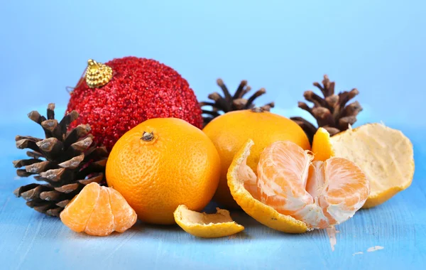 Weihnachtskomposition mit Mandarinen auf Holztisch auf blauem Hintergrund — Stockfoto