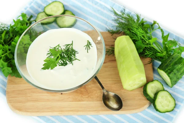 Yogurt al cetriolo in ciotola di vetro, su tovagliolo di colore, isolato su bianco — Foto Stock