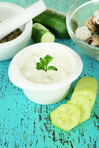 Cucumber yogurt in bowl, on color napkin, on wooden background — Stock Photo, Image