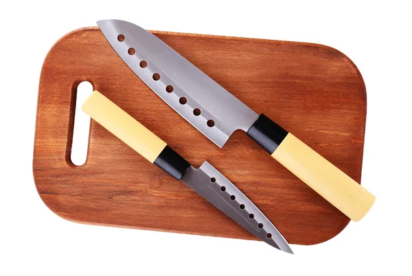 Кухонные ножи и деревянная доска, изолированные на белом — стоковое фото