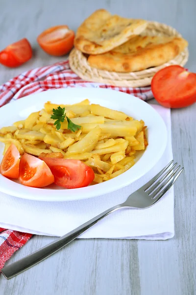 Gebakken aardappelen op plaat op houten tafel close-up — Stockfoto