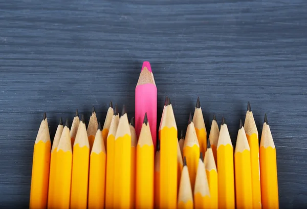 Celebratory pencil among usual pencils, on color background — Stock Photo, Image