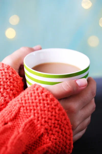 Hands holding mug of hot drink, close-up, on bright background — Stock Photo, Image