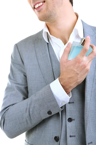 Bonito jovem usando perfume isolado no branco — Fotografia de Stock