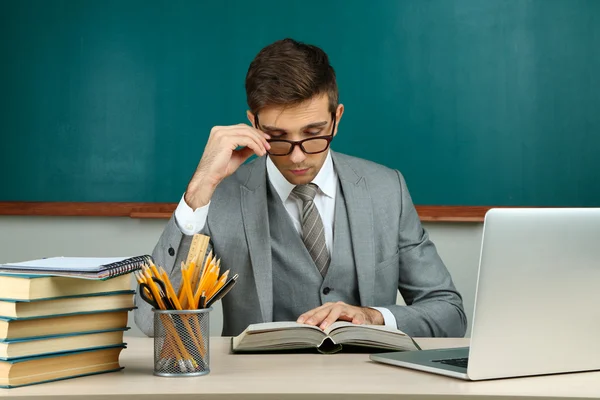 Jonge leraar zitten in school klas — Stockfoto