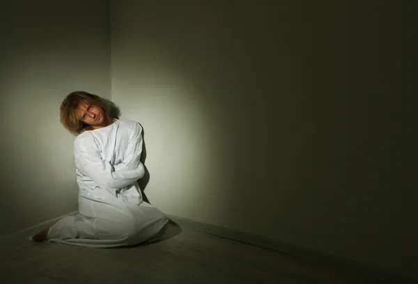 Mentally ill man in strait-jacket in room corner — Stock Photo, Image