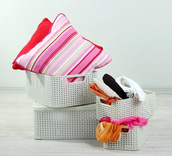 Plastic baskets with things in floor on room background — Stock Photo, Image