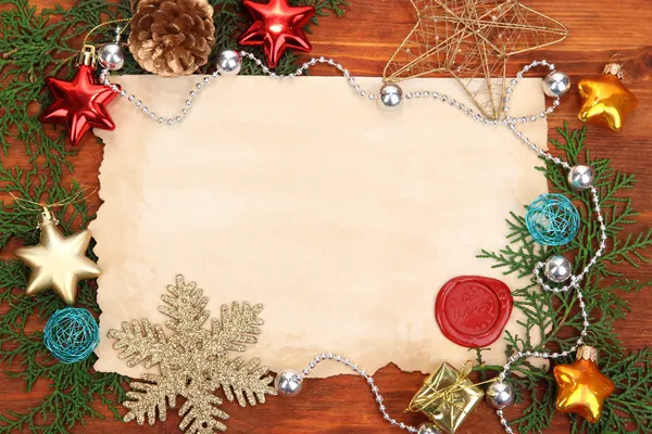 Frame with vintage paper and Christmas decorations on wooden background — Stock Photo, Image