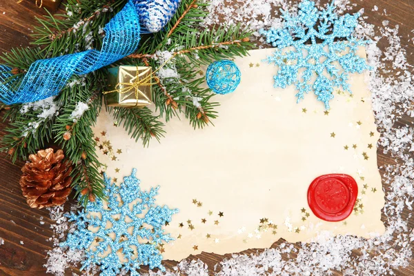 Marco con papel vintage y decoraciones navideñas sobre fondo de madera — Foto de Stock