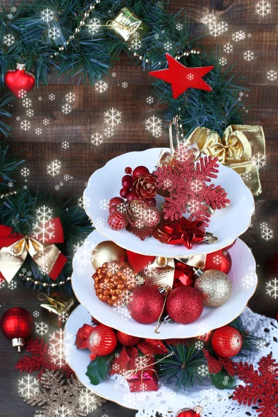 Christmas decorations on dessert stand, on wooden background — Stock Photo, Image