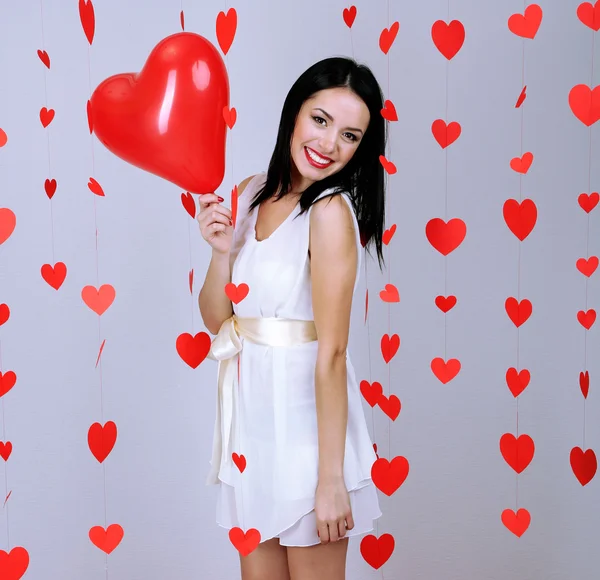 Привлекательная молодая женщина с воздушными шарами в номере на День Святого Валентина — стоковое фото