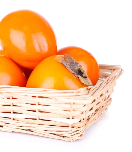 Persimmons mûrs dans un panier en osier isolé sur blanc — Photo