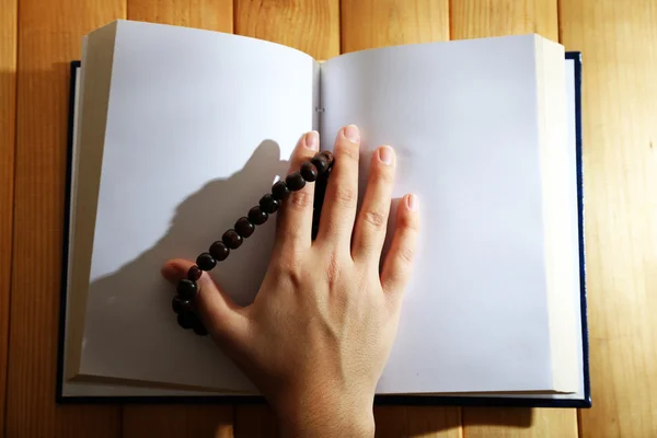 Hands with rosary and holy book, on light background — Stock Photo, Image