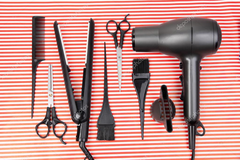 Hairdressing tools on striped red background
