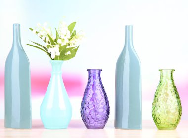 açık renkli raf üzerinde farklı dekoratif vazolar
